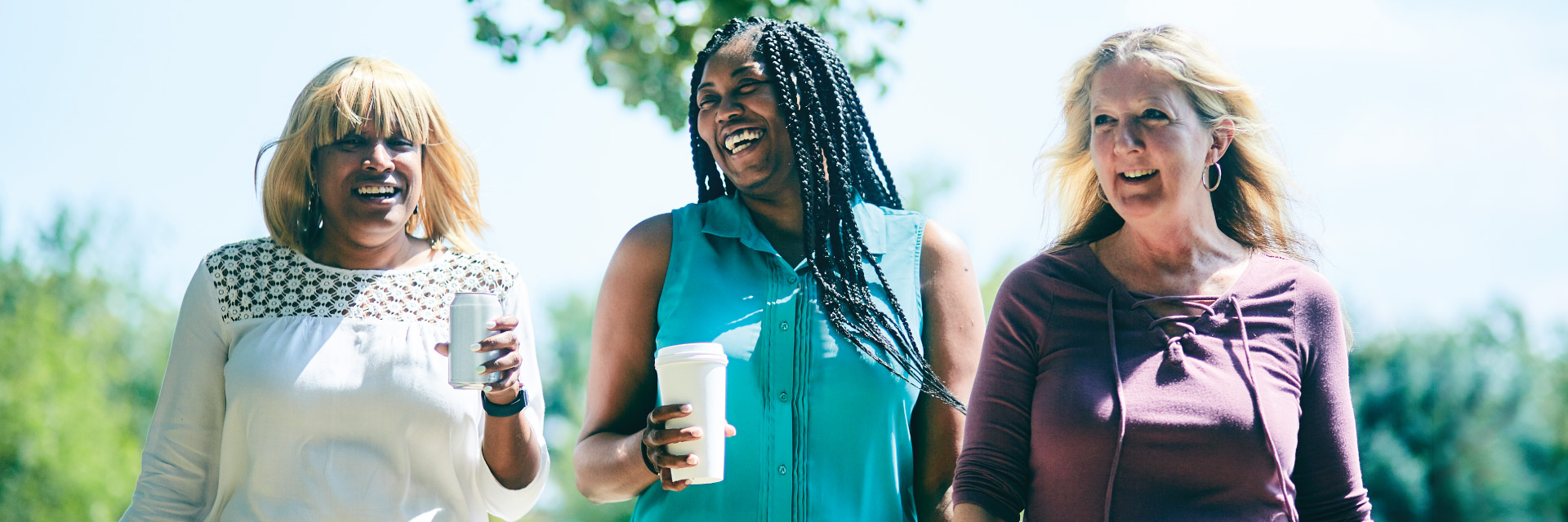 Three women walk and laugh outside on their lunch break.