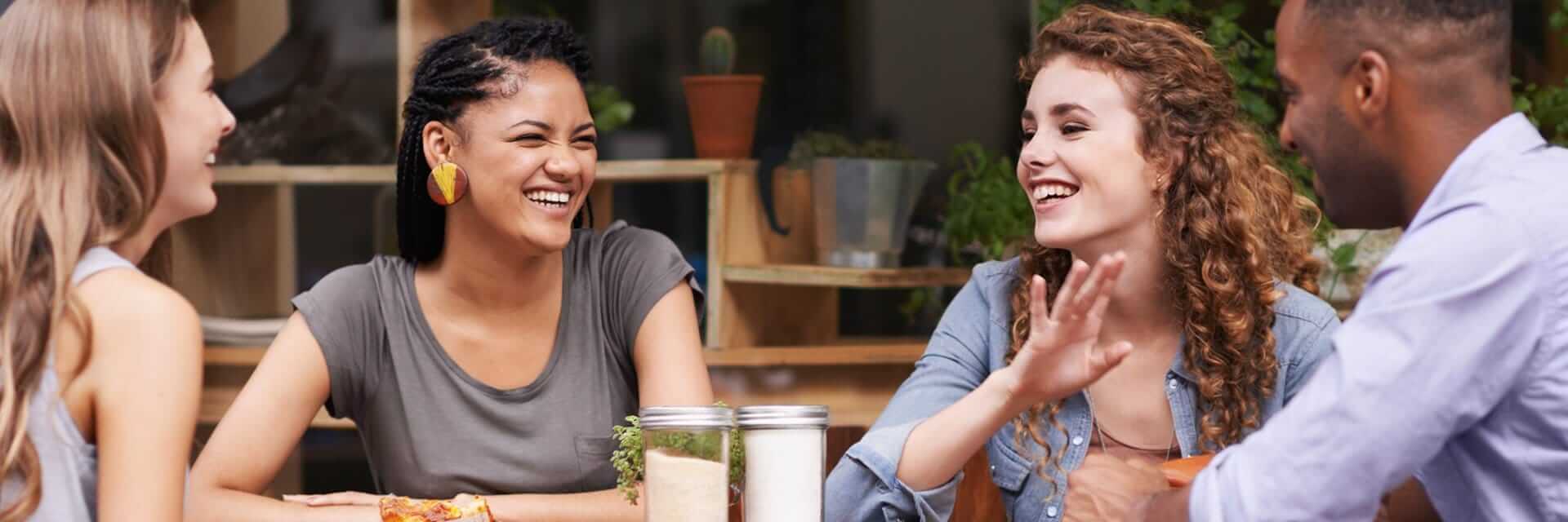 A group of friends enjoying an afternoon outside at a table together.